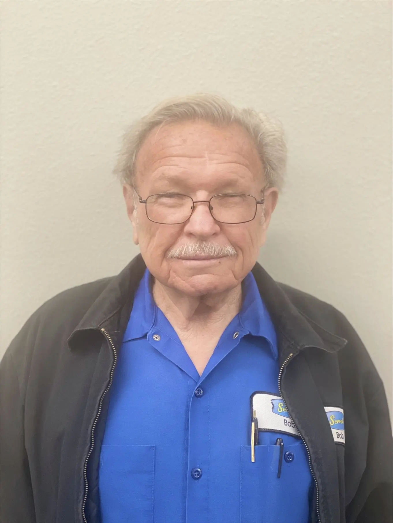 smiling old man with white hair and a white mustache