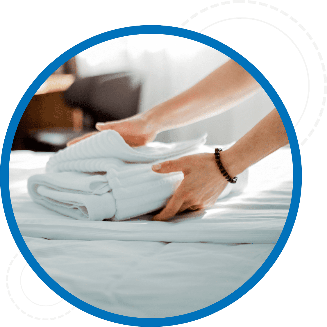 Close up of hands setting down a clean towel on a bed
