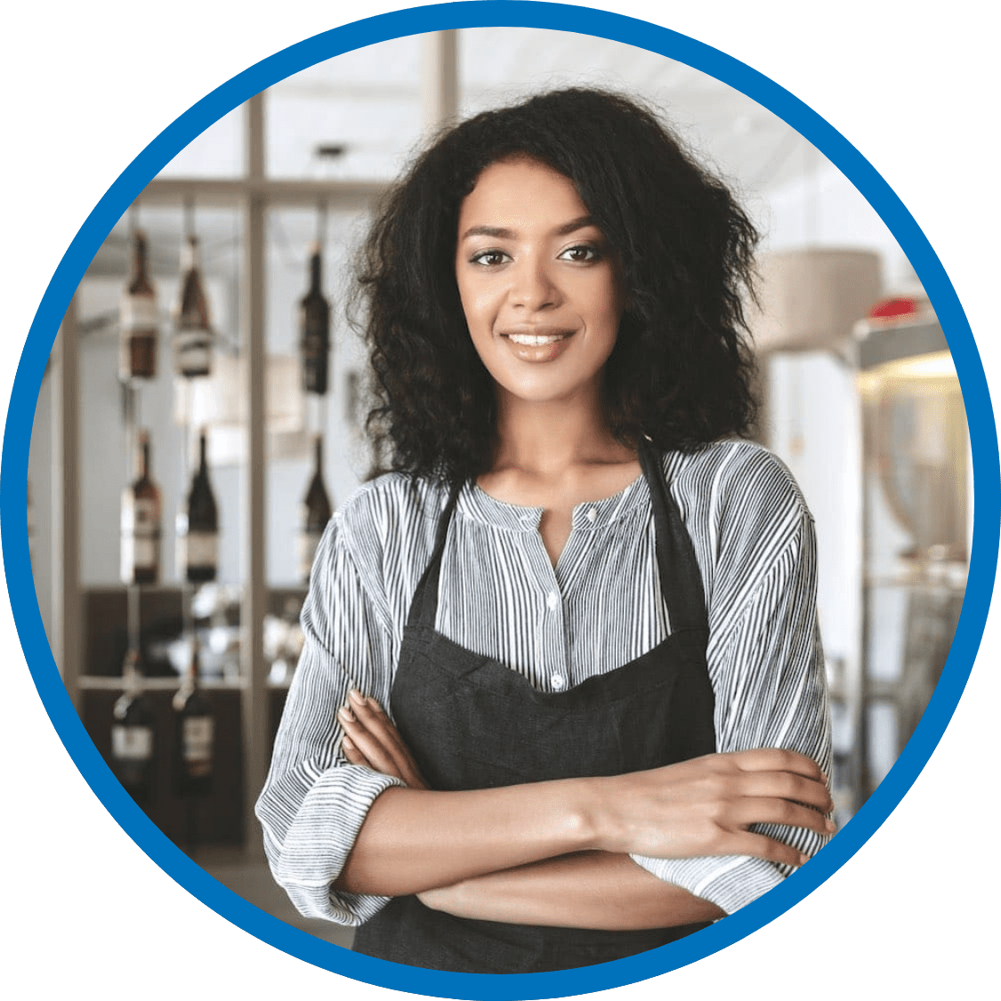 Smiling woman wearing a black apron in a resturant
