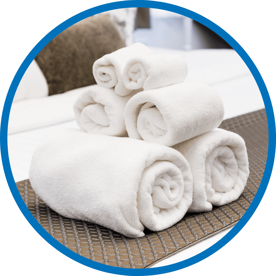 Neatly folded white towels stacked on a freshly made bed in a hospitality business