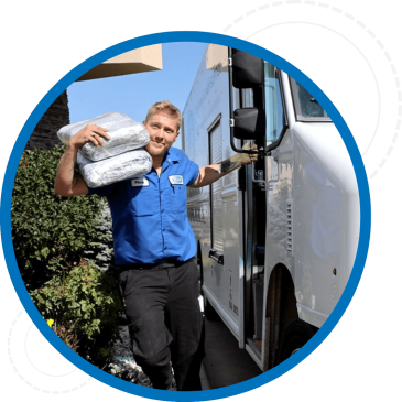 Severall employee exiting delivery van carrying uniforms on his shoulder.